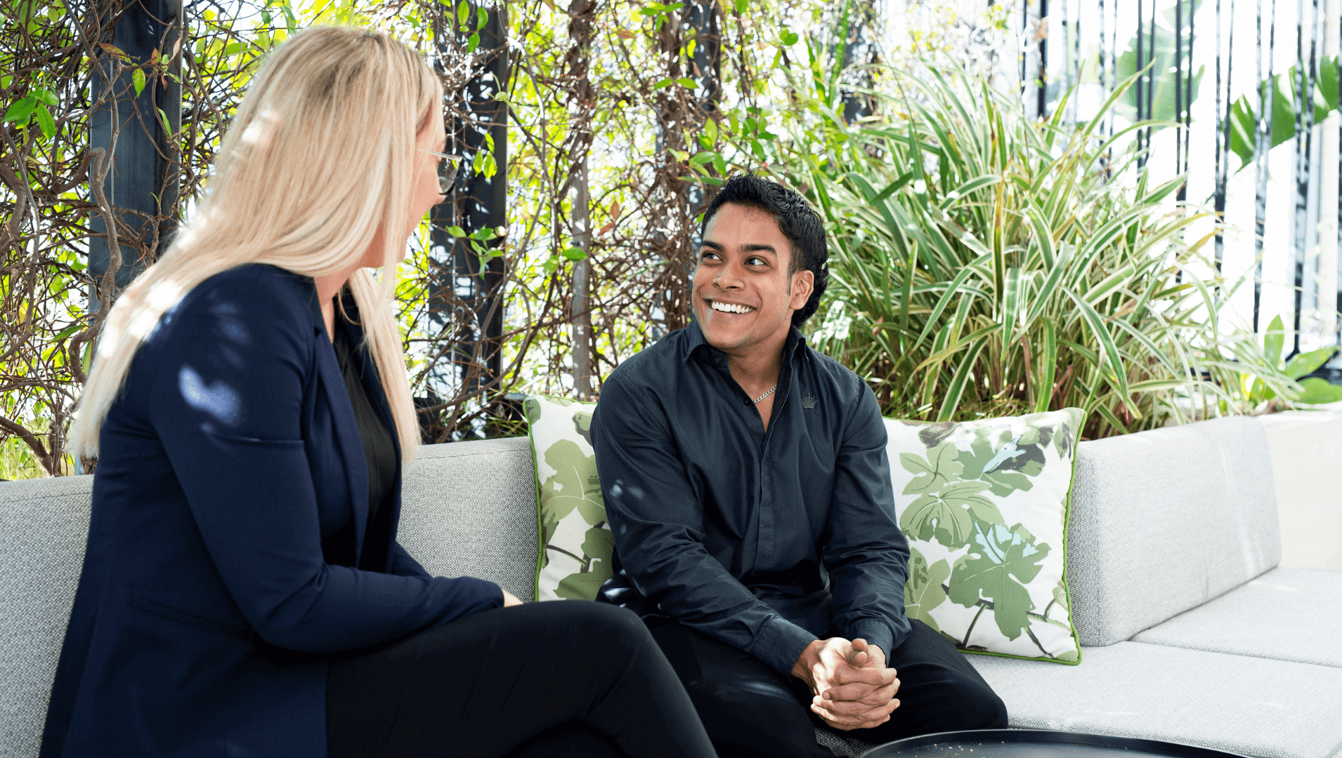 Clyde speaking with a woman on a white couch