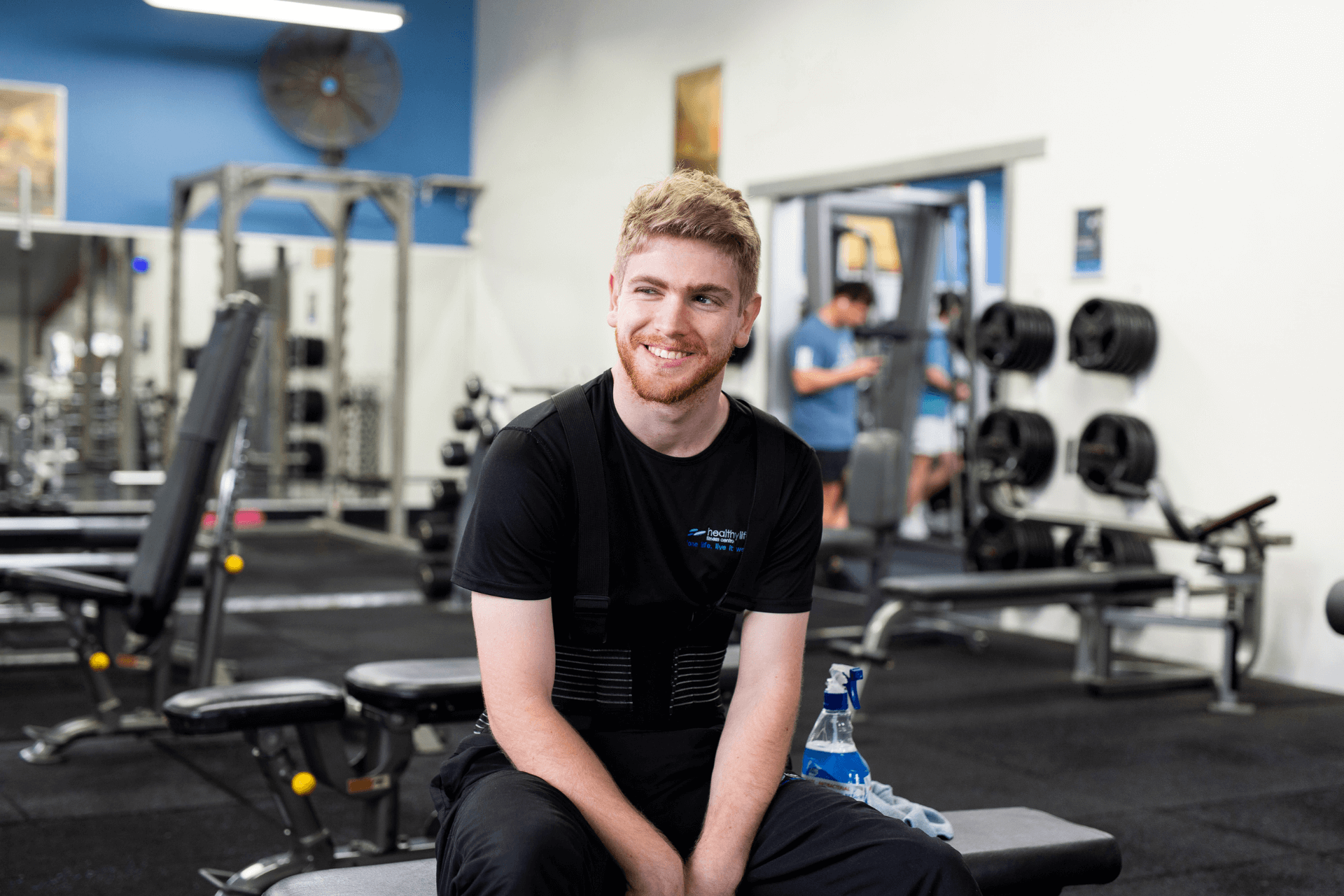 man sitting at a bench in the gym